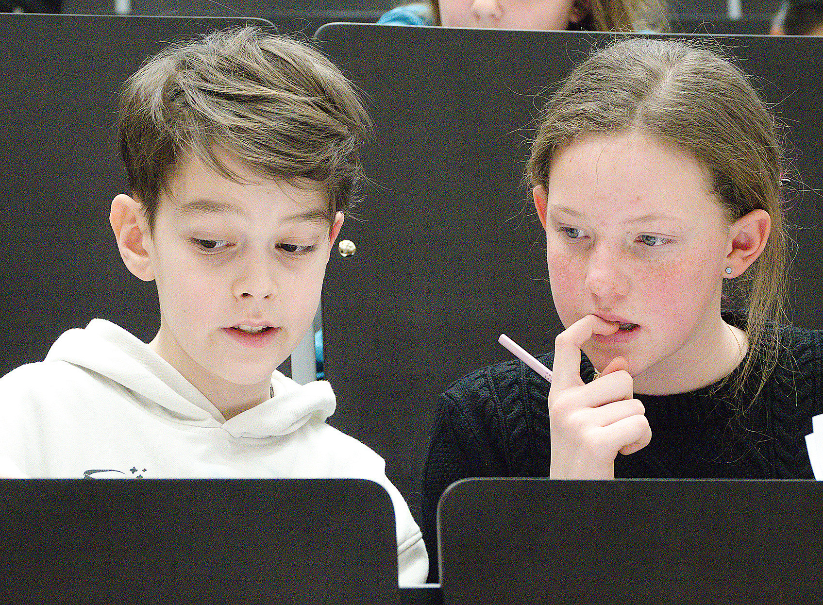 Two children taking part in a mathematics competition in a lecture hall at the University of Graz 