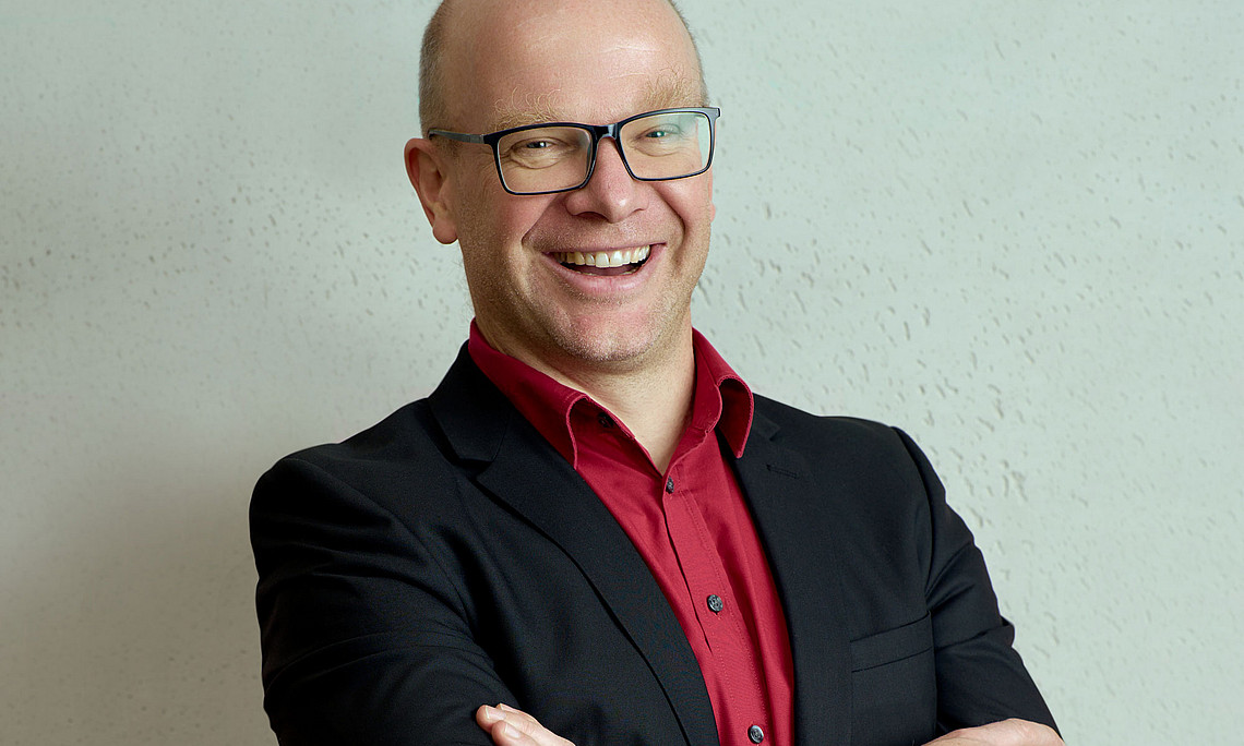 Wirtschaftsinformatiker Stefan Thalmann lachend und mit verschränkten Armen