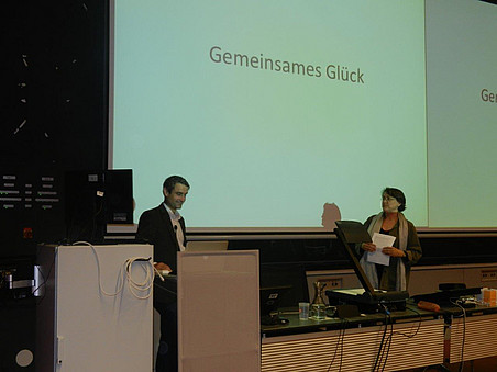 Vortragender und Moderatorin vor Präsentation "Gemeinsames Glück" ©Denkzeitraum