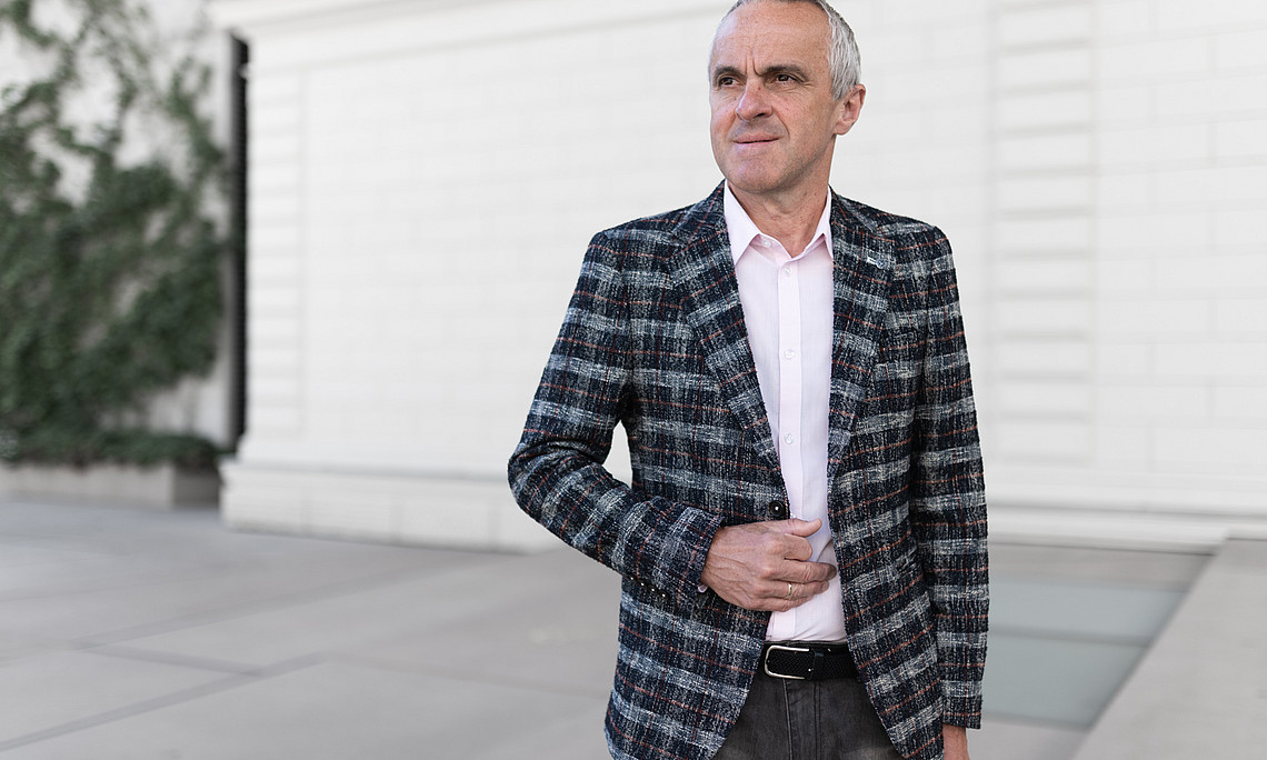 A man in a checked jacket is standing on a gently sloping flight of steps