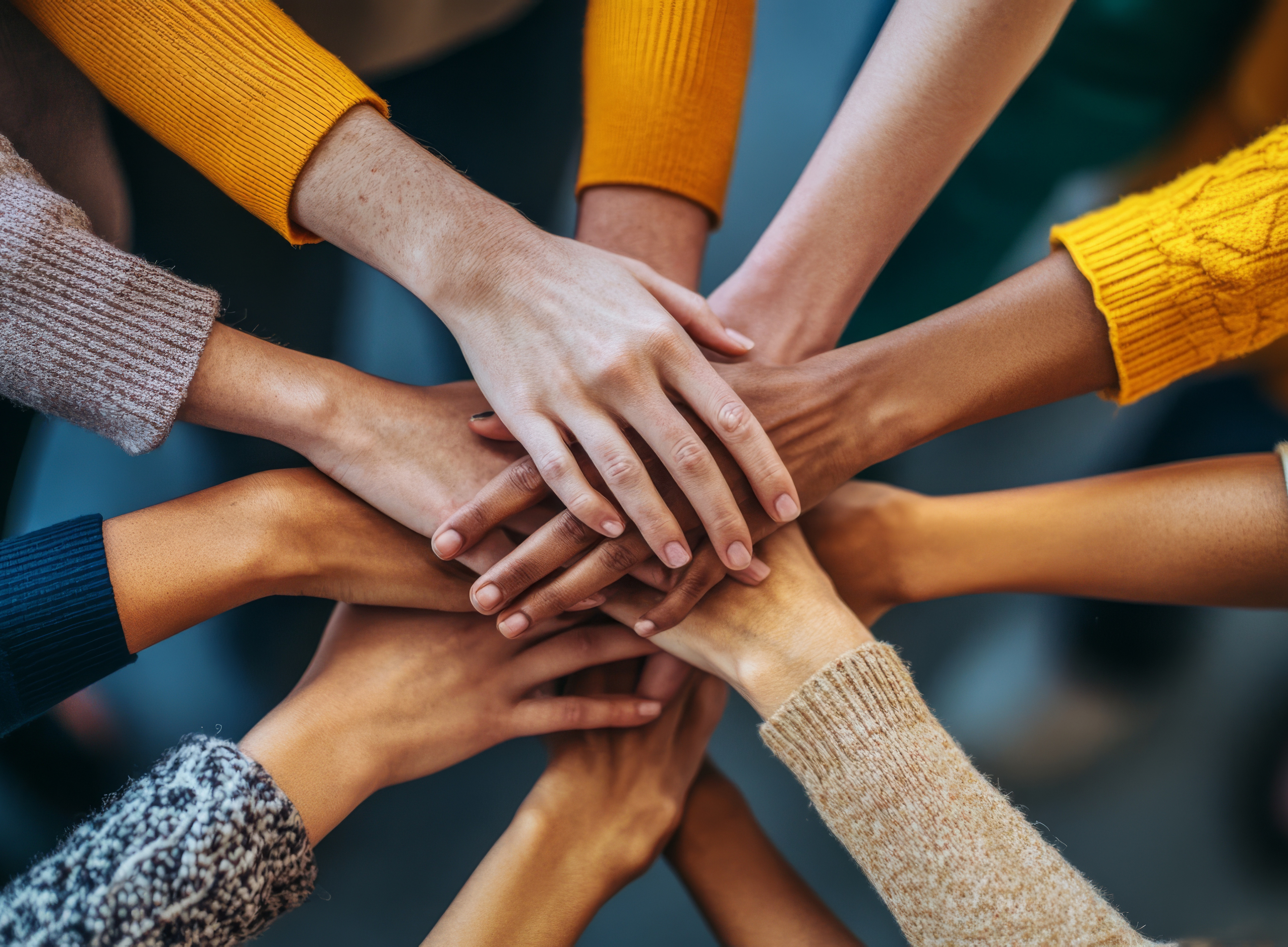 People who work together and put their hands on them to emphasise the collaboration in the forum 