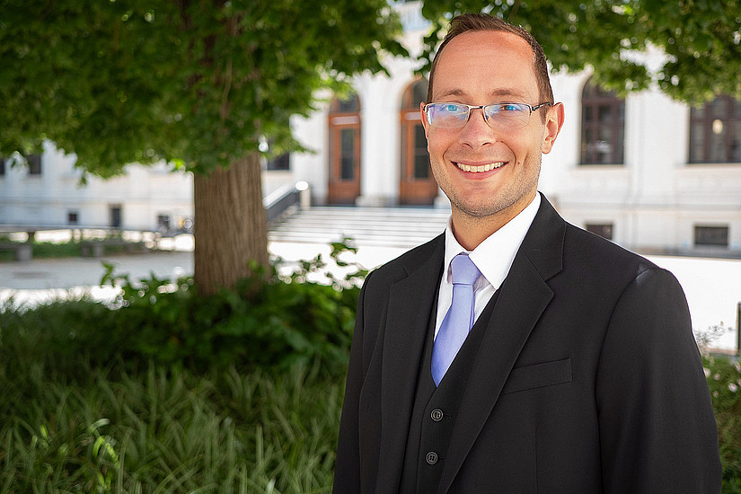 Ein Mann steht vor einem Baum 