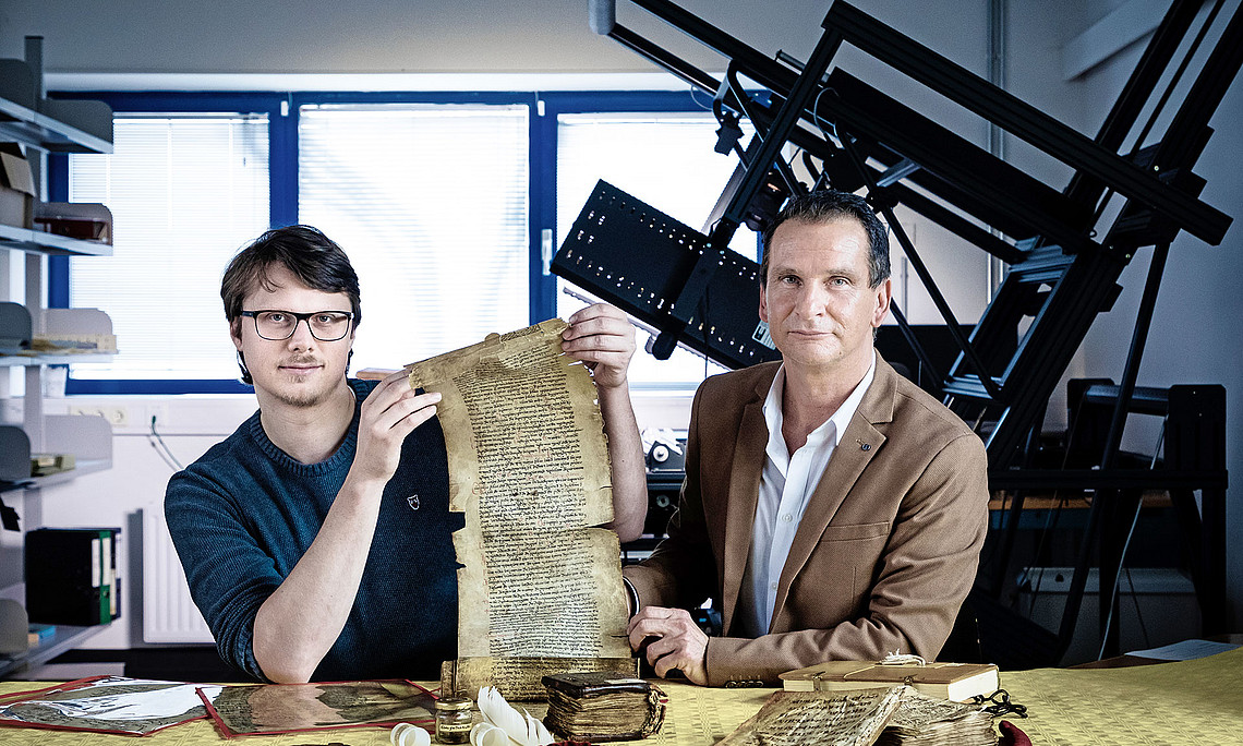 Hans Clausen (links) und Karl Lenger machen sich die neuesten Technologie für ihre Forschungen zunutze. Mithilfe spezieller Wellenlängen des Lichts versuchen sie in die Tiefen von alten Schriften zu blicken. Ob das Verfahren fruchtet, sollen nun erste Tests zeigen. Foto: Uni Graz/Konstantinov