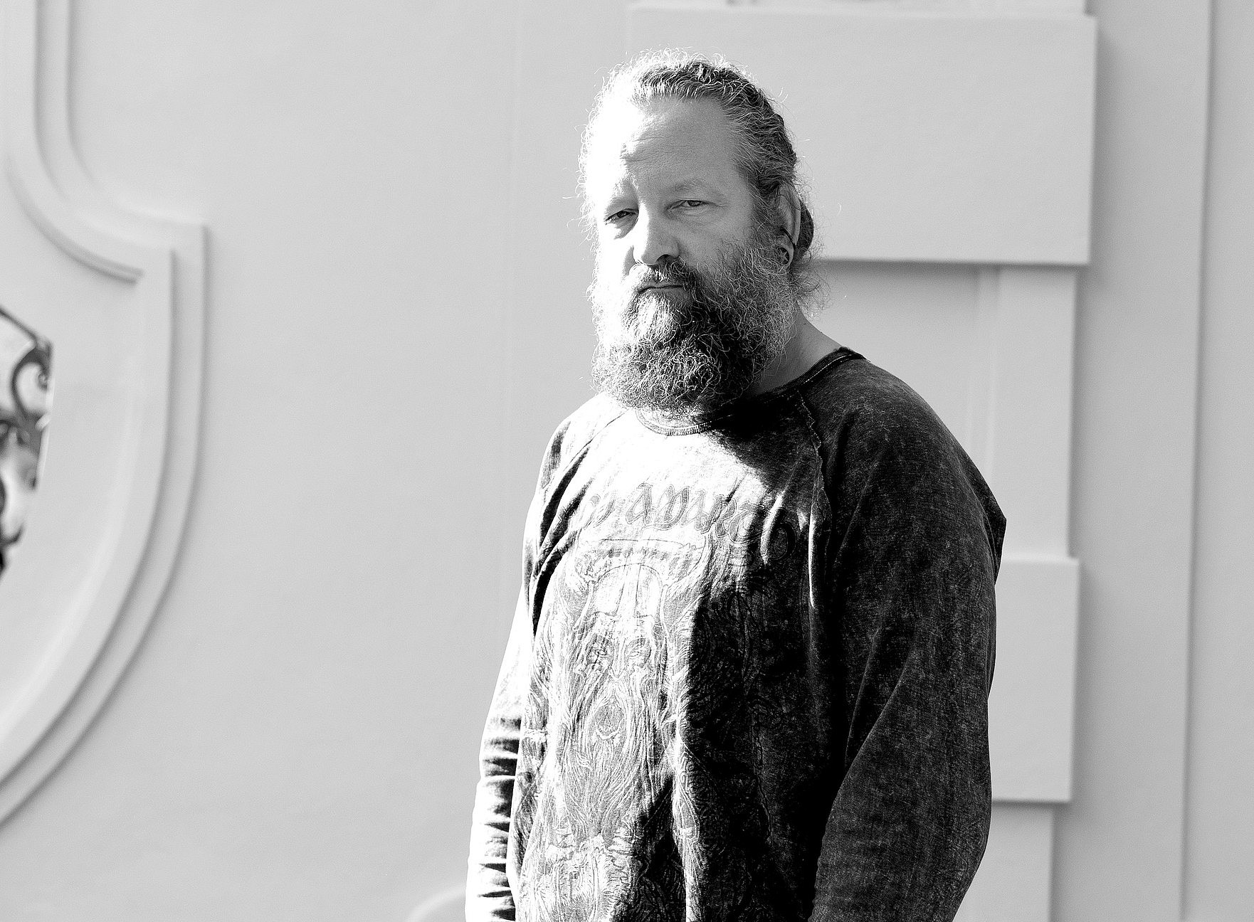 Ein Mann steht vor einer Hauswand 