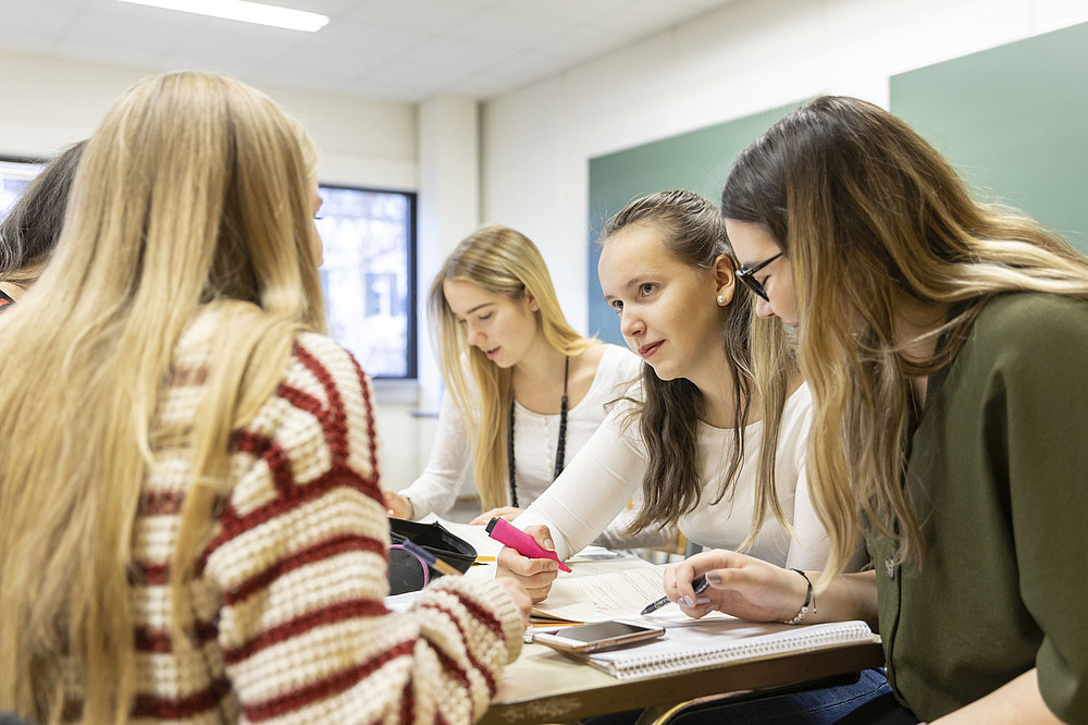 4 Schülerinnen sitzen im Klassenzimmer und lernen gemeinsam. Sie symbolisieren den Forschungsschwerpunkt Argumentieren. ©NikolaMilatovic