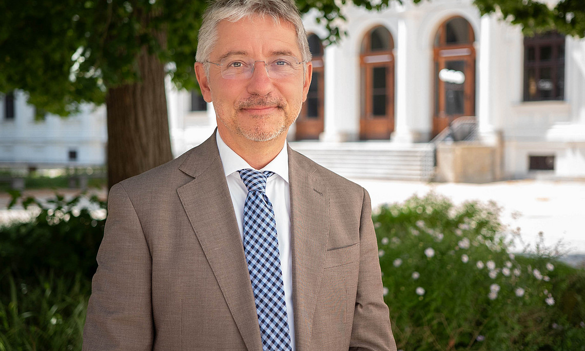 Foto von Christian Aschauer im Innenhof des Hauptgebäudes der Universität Graz.