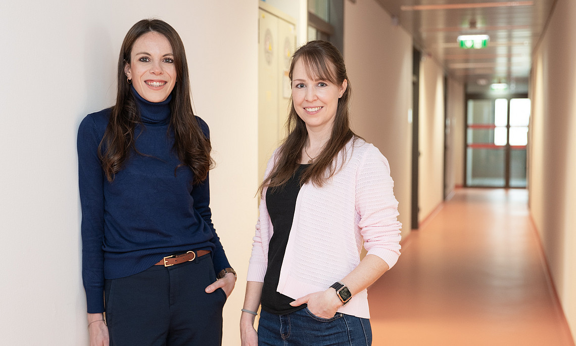Two women are standing in a corridor
