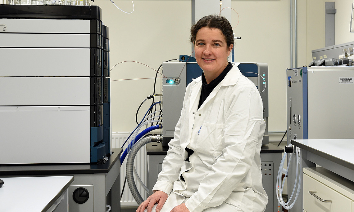 Pharmacist Solveigh Koeberle sits in front of a piece of equipment in the laboratory.