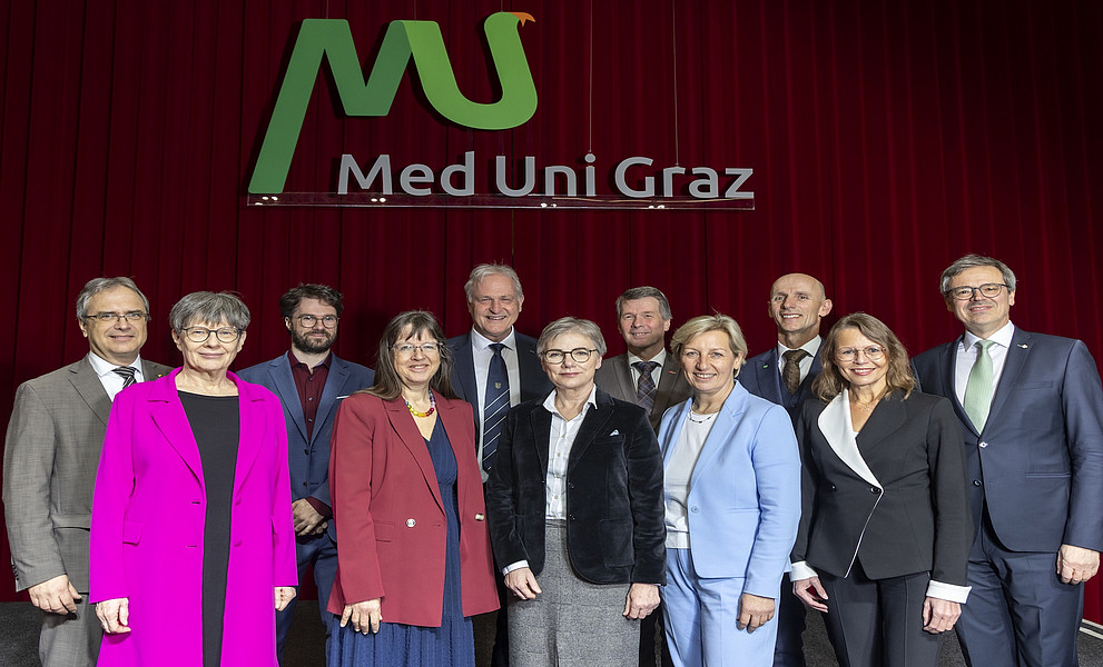 Eine Gruppe von Frauen und Männern vor einem roten Vorhang