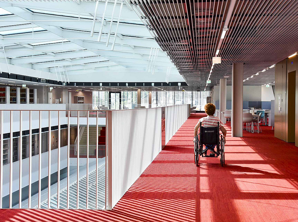 A woman in a wheelchair explores the upper floors of the main library. ©Uni Graz/Schwarz