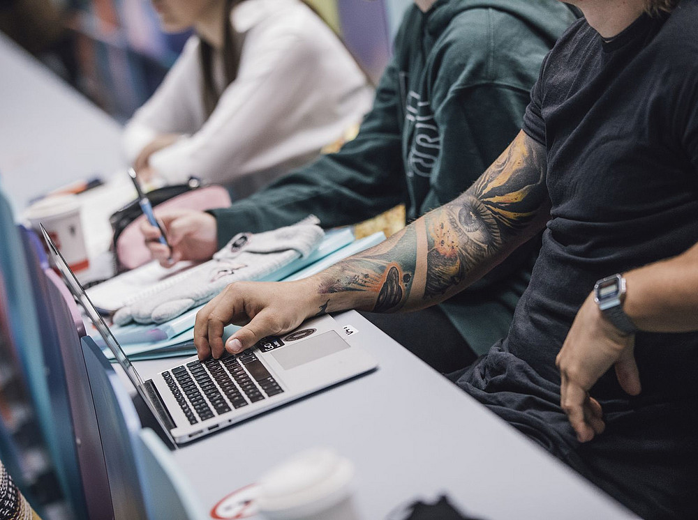 Personen sitzen an einem Tisch vor einem aufgeklappten Laptop ©Kanizaj/Uni Graz