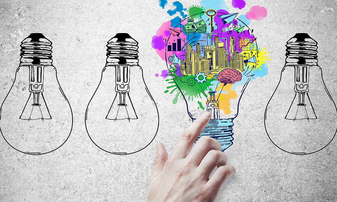 hand pointing at abstract drawn lamps and business sketch on concrete background. idea concept