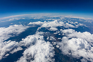 View of the Earth from above, irregular white bands of clouds, blue horizon