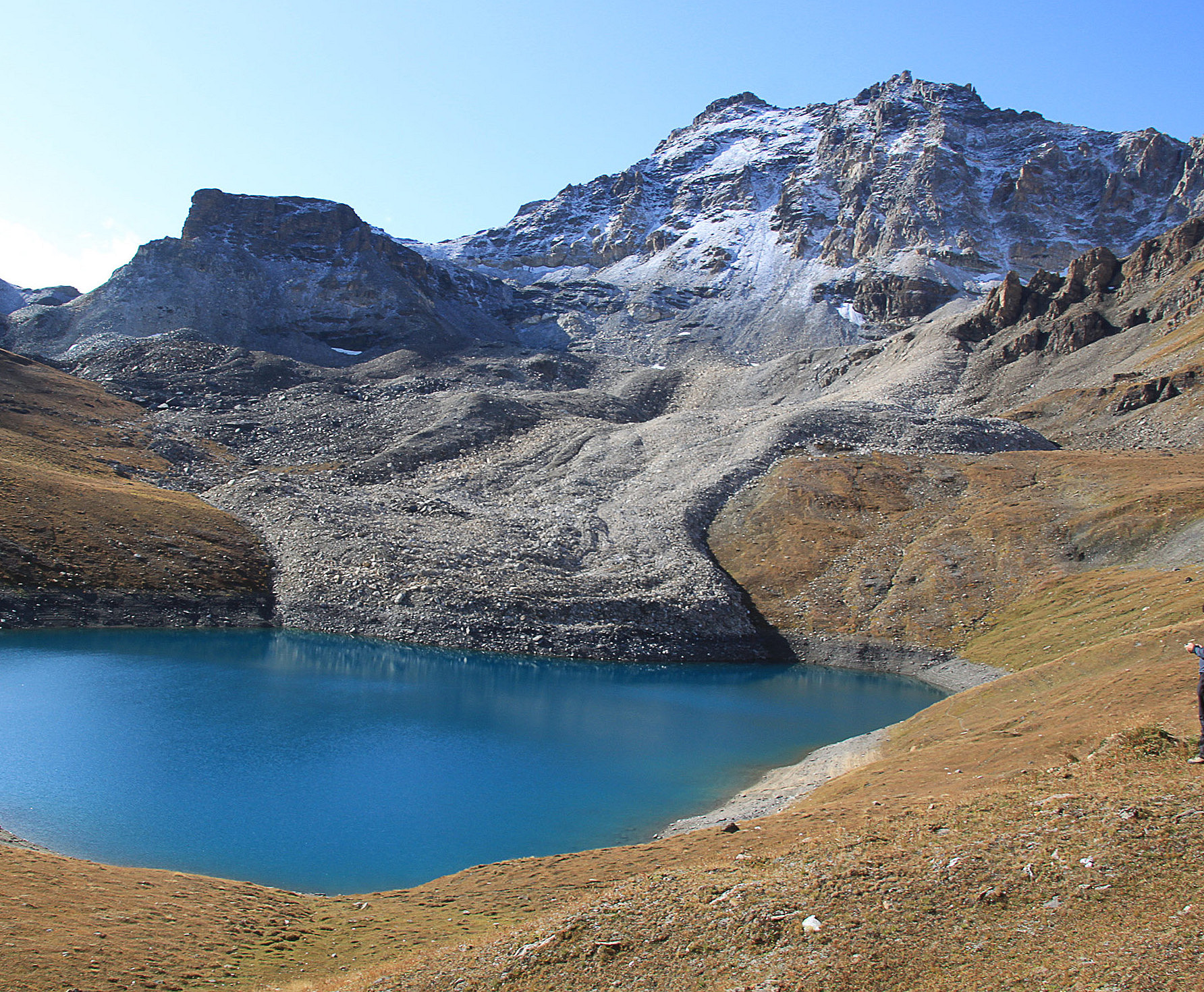 Block glacier flowing into a mountain lake, snow-covered rock in the background ©Andreas Kellerer-Pirklbauer/Uni Graz