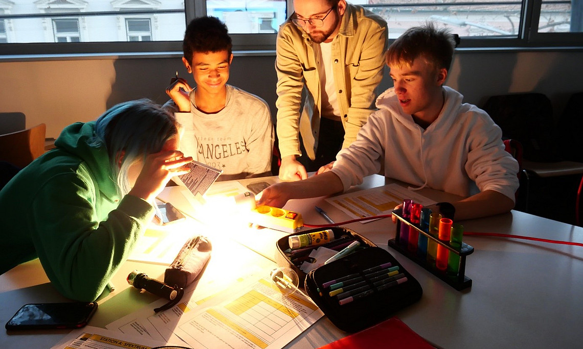 Schüler:innen und Studierender bei einer Station zur Spektralanalyse. Foto: UniGraz/Obczovsky 