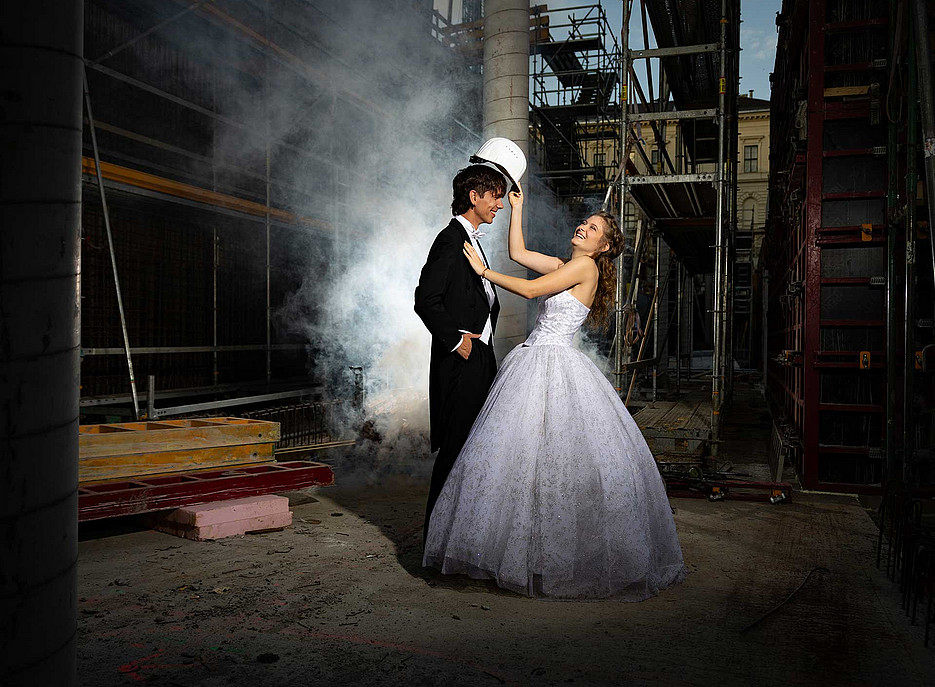 Paar in eleganter Ballkleidung auf der Baustelle 