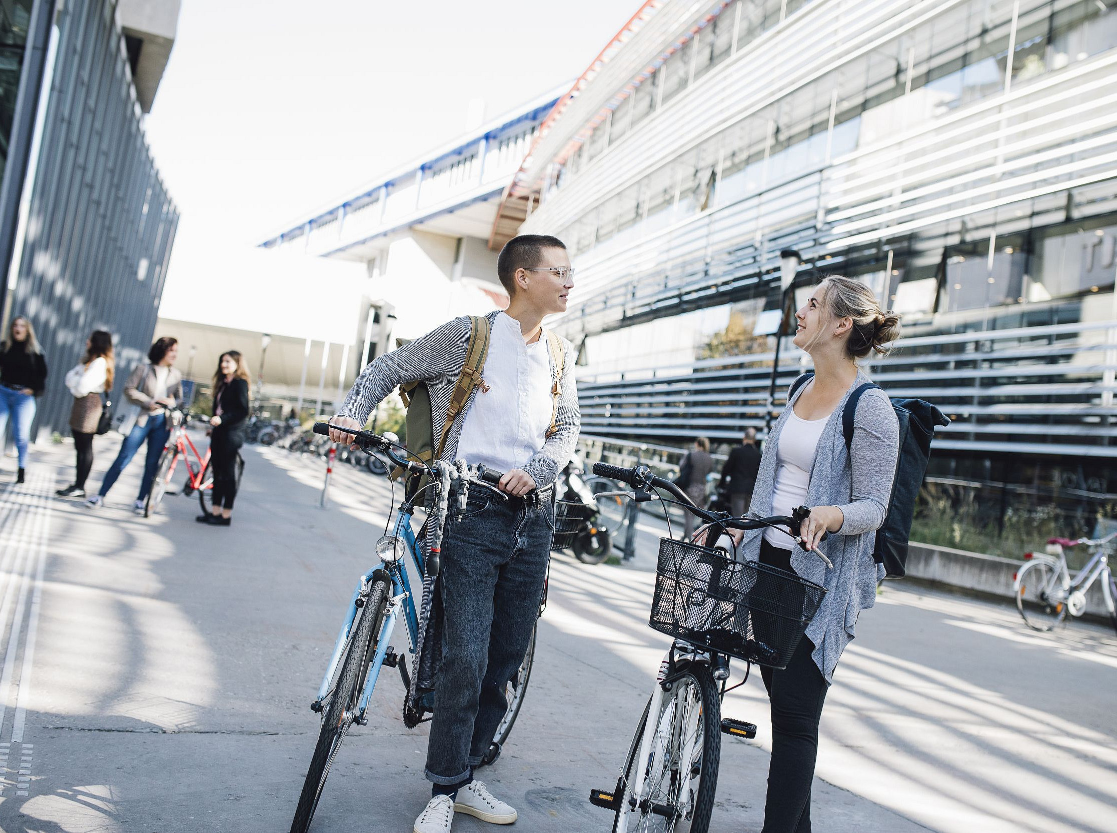 Zwei Studierende mit dem Fahrrad vor dem RESOWI-Zentrum während einer Unterhaltung ©Uni Graz/Kanizaj