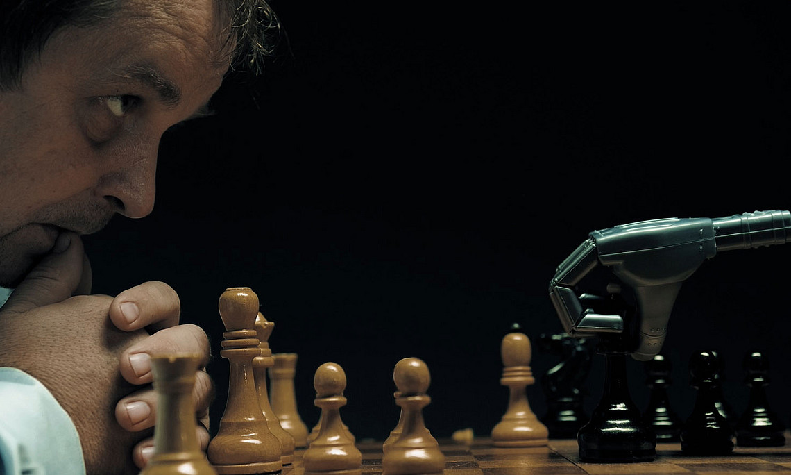 Man plays chess with a robot and watches its move in fear