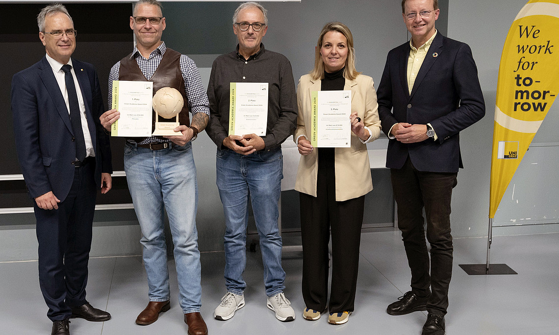 Rector Peter Riedler, Harald Stelzer, Walter Kurz, Romana Rauter and Gottfried Kirchengast at the presentation of the Green Academia Award with certificates, trophy and Uni Graz beach flag with the inscription "we work for tomorrow"