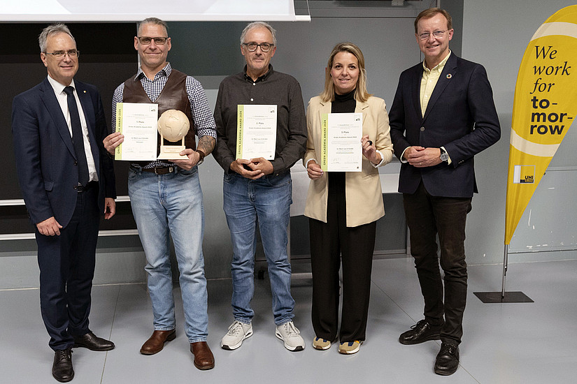 Rector Peter Riedler, Harald Stelzer, Walter Kurz, Romana Rauter and Gottfried Kirchengast at the presentation of the Green Academia Award with certificates, trophy and Uni Graz beach flag with the inscription "we work for tomorrow"