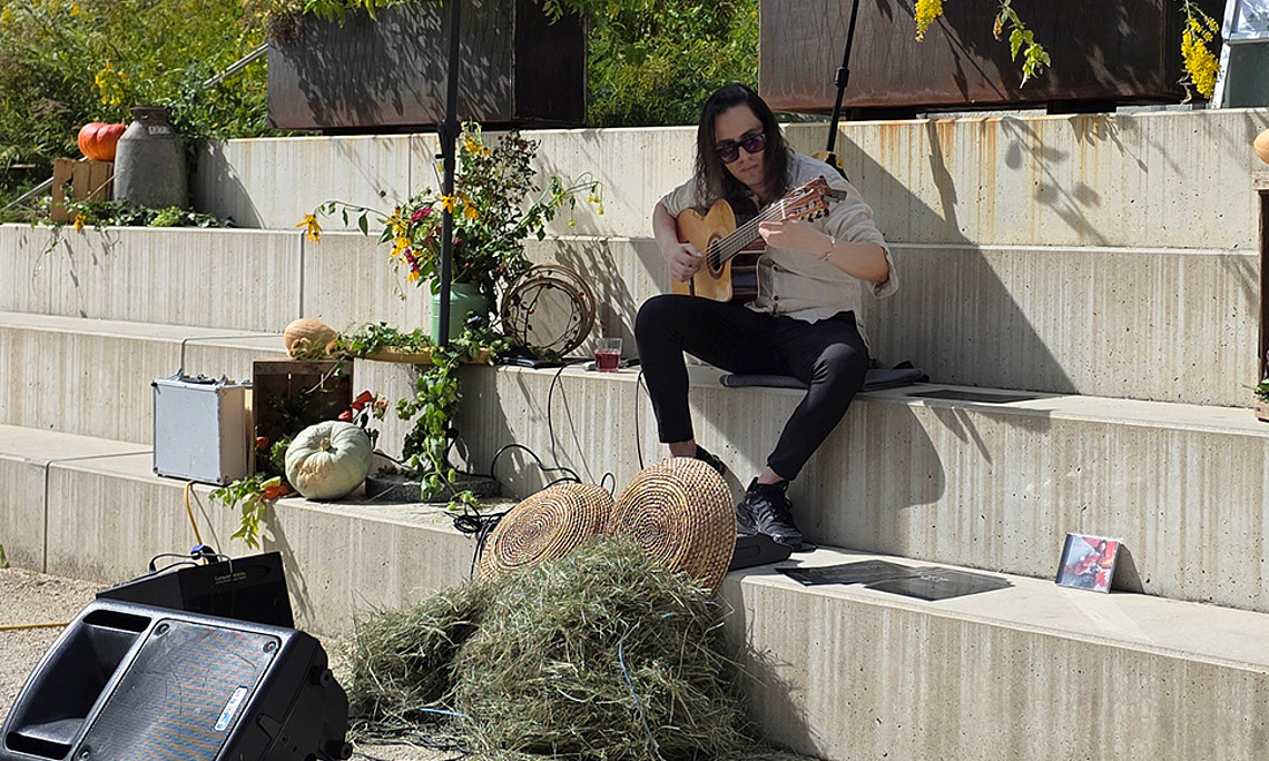 Samu Guitar spielt auf Stufen im Botanischen Garten der Universität Graz