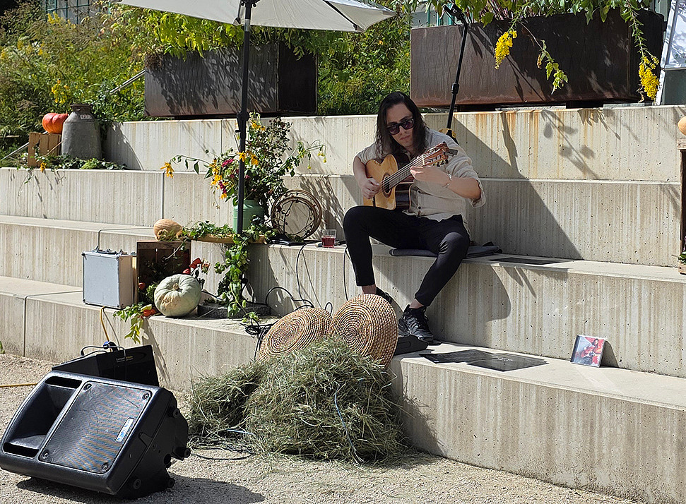 Samu Guitar spielt auf Stufen im Botanischen Garten der Universität Graz 