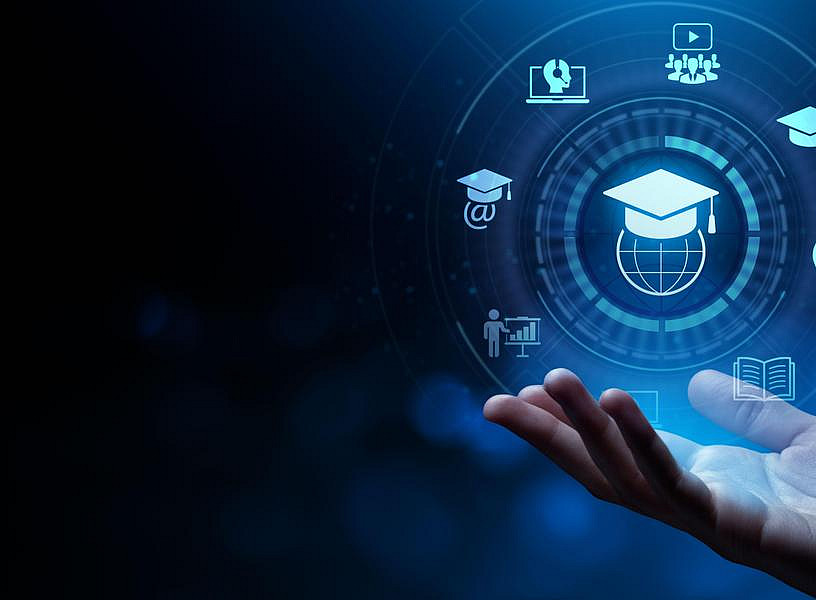 The image shows an open human hand in the lower right corner, gently cupped as if supporting or presenting something. Above the hand, in the center, there is a glowing digital interface with a circular design. Inside the circle is an icon of a graduation cap resting on a globe, symbolizing global education and knowledge. ©AdobeStock_476051263