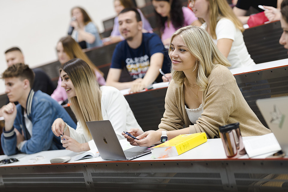 Studentin im Hörsaal mit Kodex