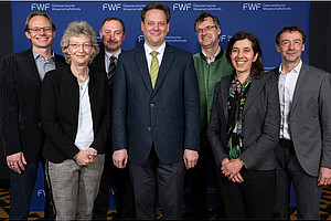 Group photo of the Board of Directors of the Cluster of Excellence Circular Bioengineering, with the FWF logo on the wall in the background