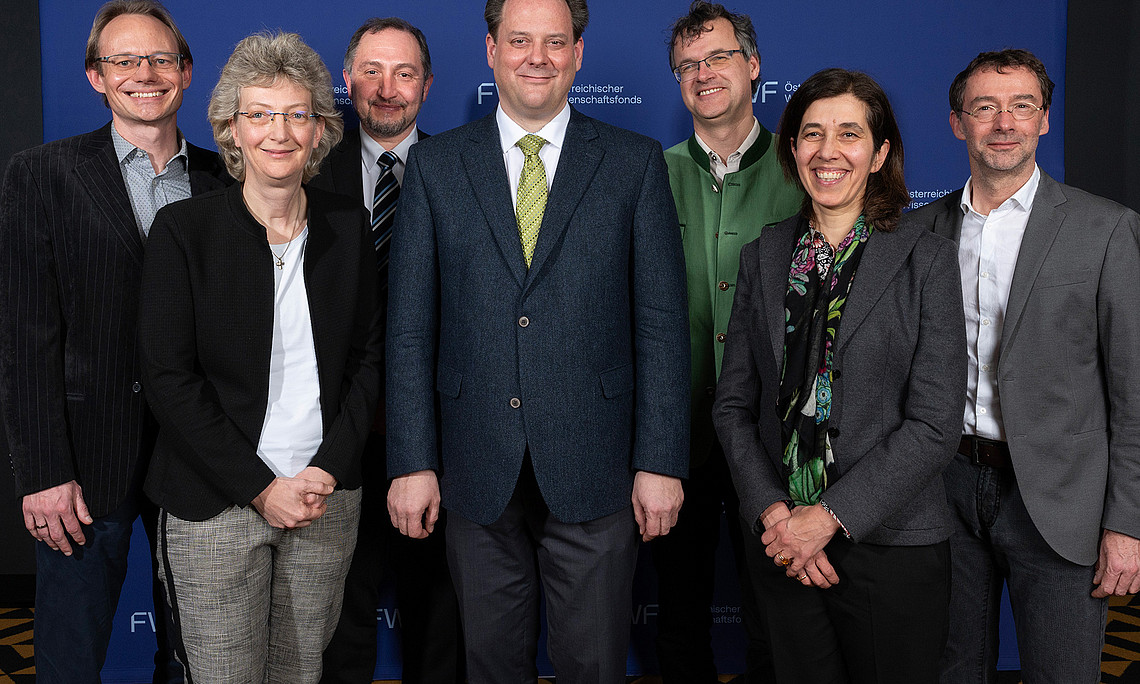 Group photo of the Board of Directors of the Cluster of Excellence Circular Bioengineering, with the FWF logo on the wall in the background