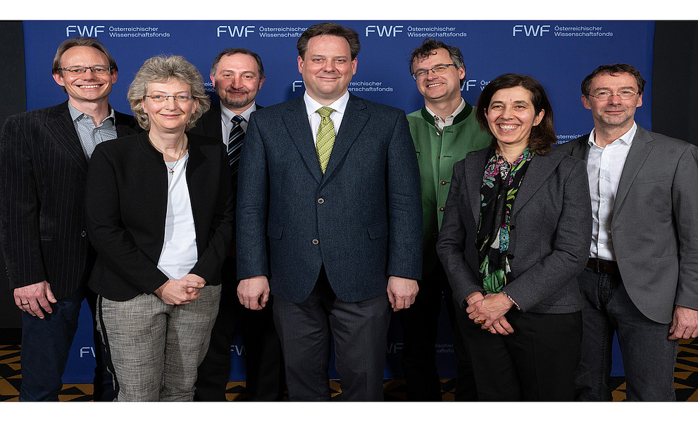 Gruppenfoto vom Direktorium des Exzellenzclusters Circular Bioengineering, auf der Wand im Hintergrund das FWF-Logo