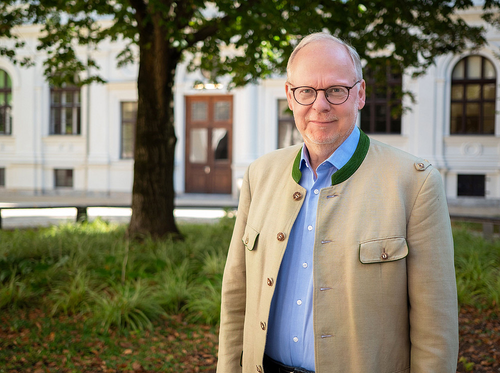 Meinrad Handstanger im Portrait im Innenhof der Hauptgebäude der Universität Graz 