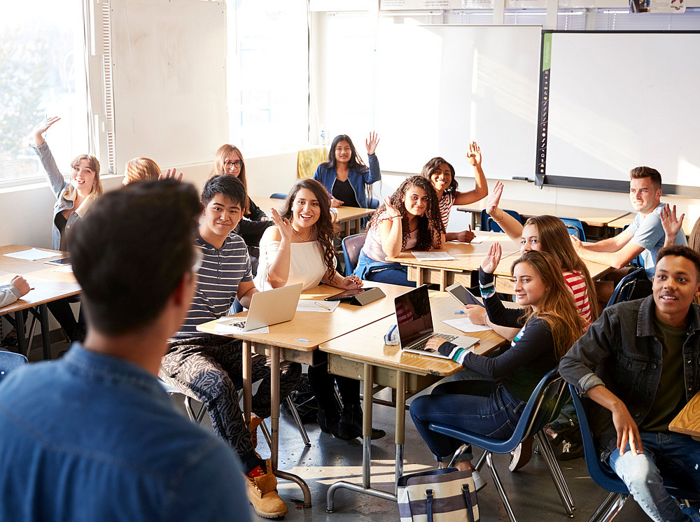 Lehrer steht vor Schüler:innen in einem Klassenraum ©Monkey Business - stock.adobe.com