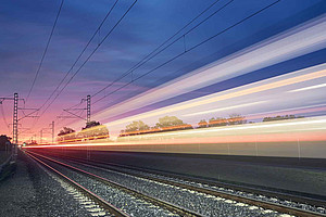 Railway tracks in the evening with colourful strips of light