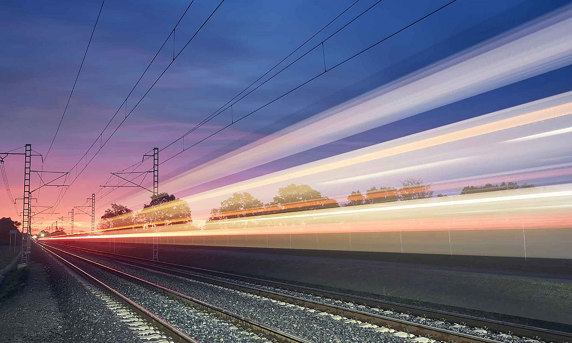 Bahngleise am Abend mit bunten Lichtstreifen