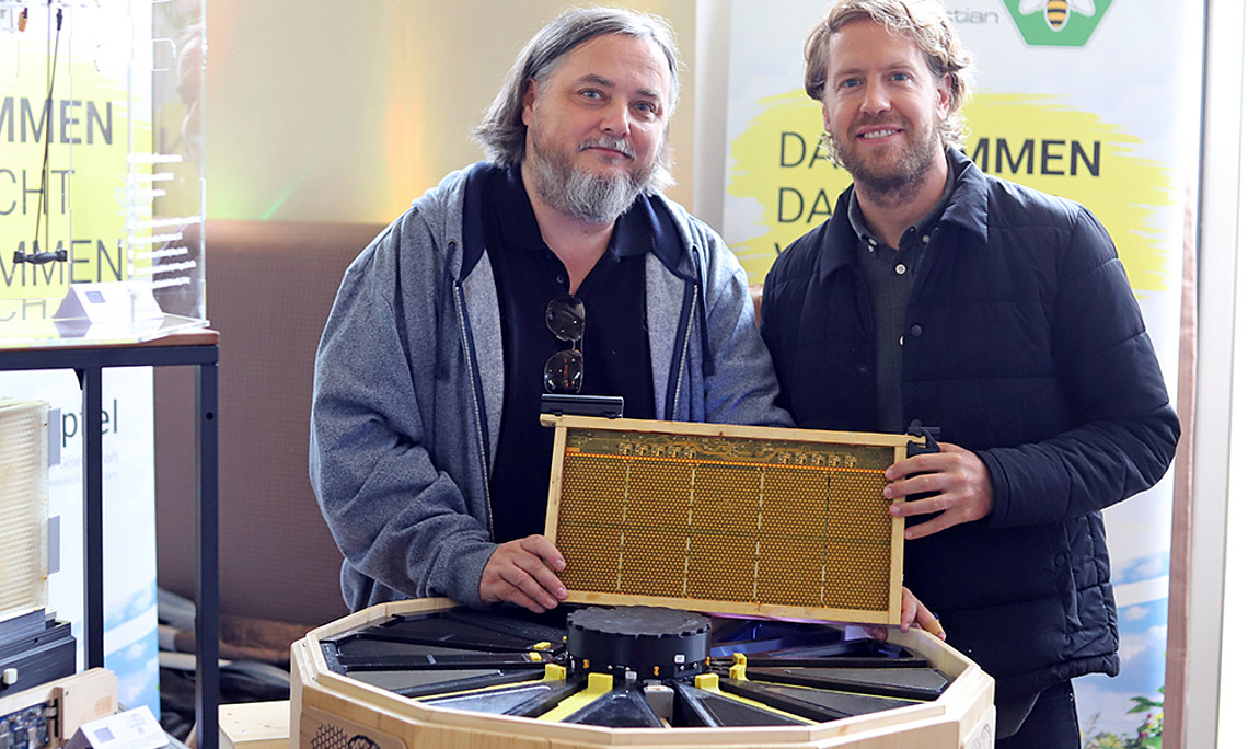 Hightech auch für die Natur: Biologe Thomas Schmickl (l.) zeigt Formel-1-Weltmeister Sebastian Vettel den Bienenstock der Zukunft. Foto: EU FET Projekt Hiveopolis