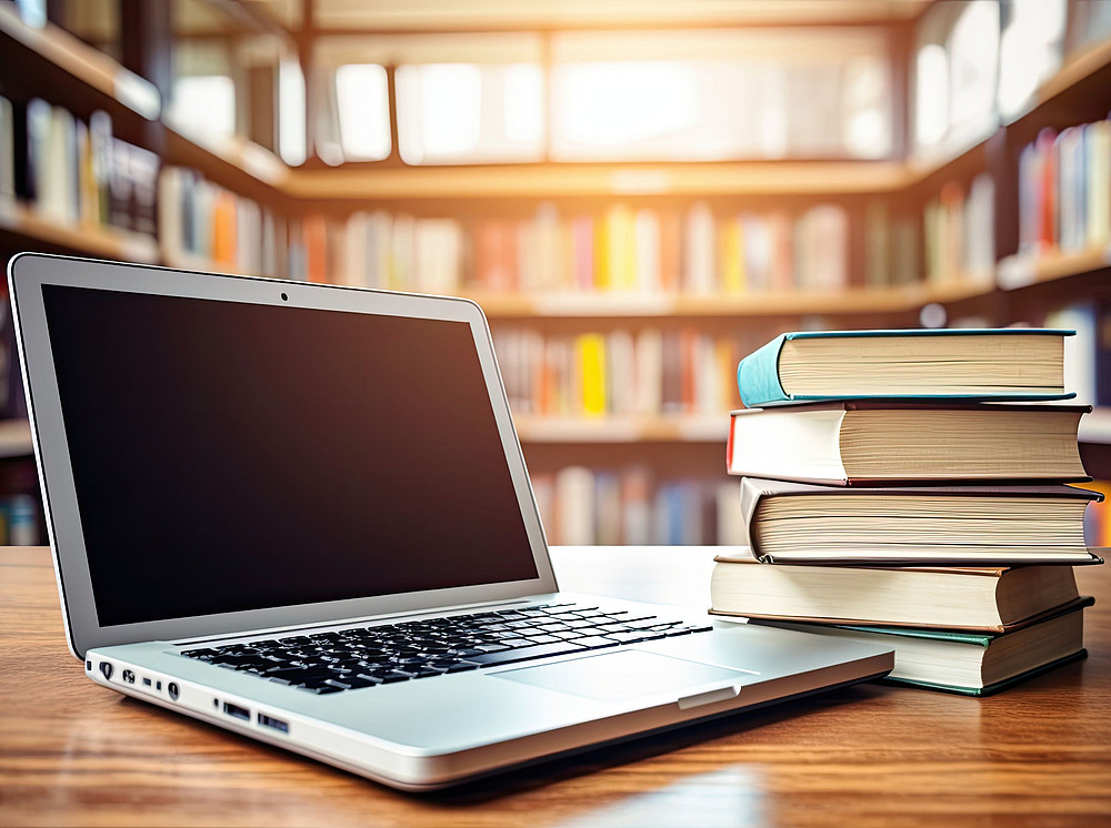 Laptop und Bücherstapel in einer Bibliothek ©Marat - stock.adobe.com