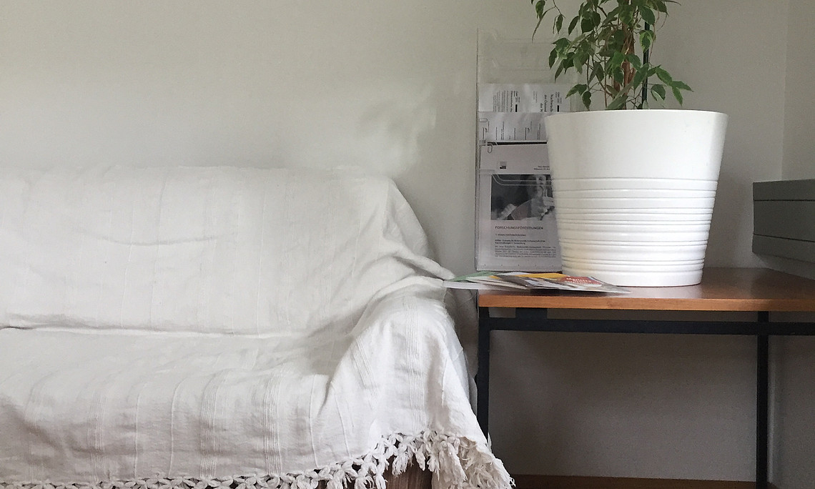 [Translate to English:] Couch and Table with a plant