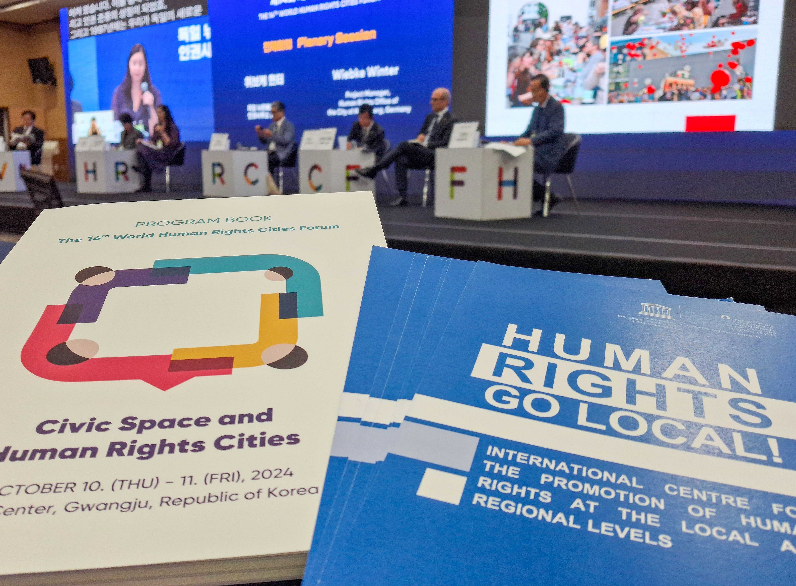 Dokumente des 14th World Human Rights Cities Forum vor der Bühne ©World Human Rights Cities Forum