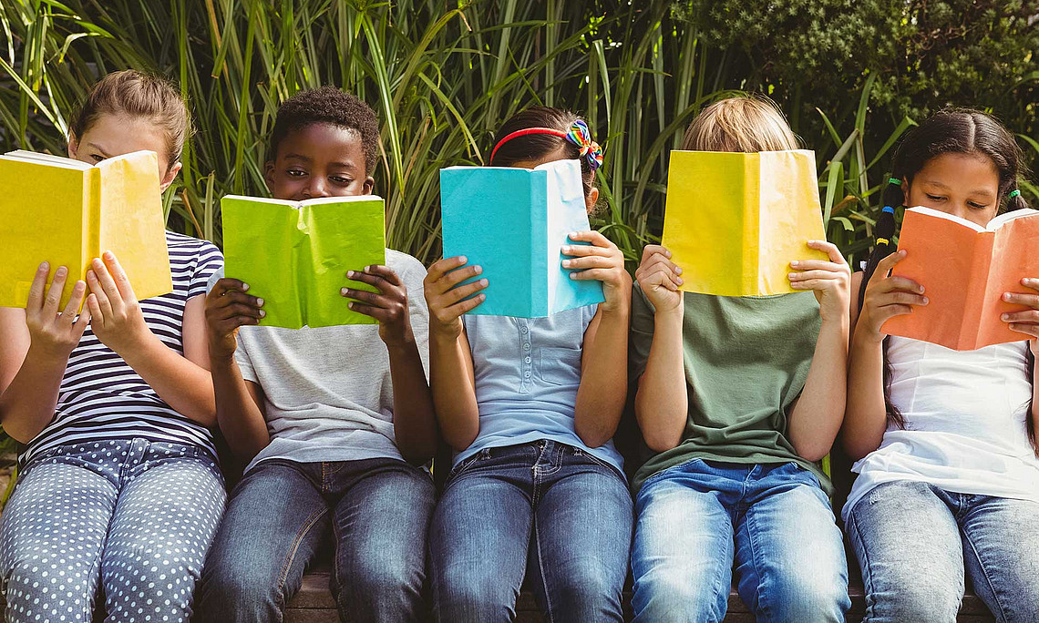 Kinder lesen Bücher im Freien