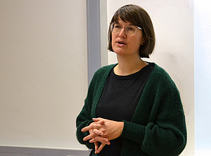 eine Frau mit schulterlangen braunen Haaren und Brille, die vor einer weißen Wand steht und spricht ©Uni Graz/Braunegger