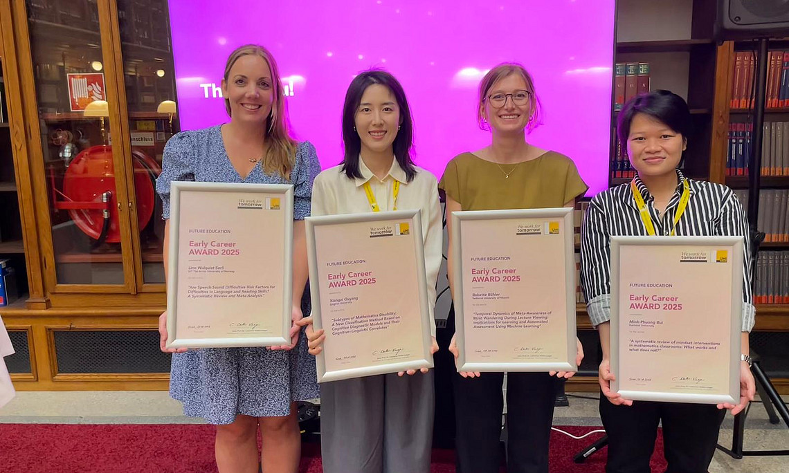 two white woman and two asian women are smiling for a photo while posing with their awards.