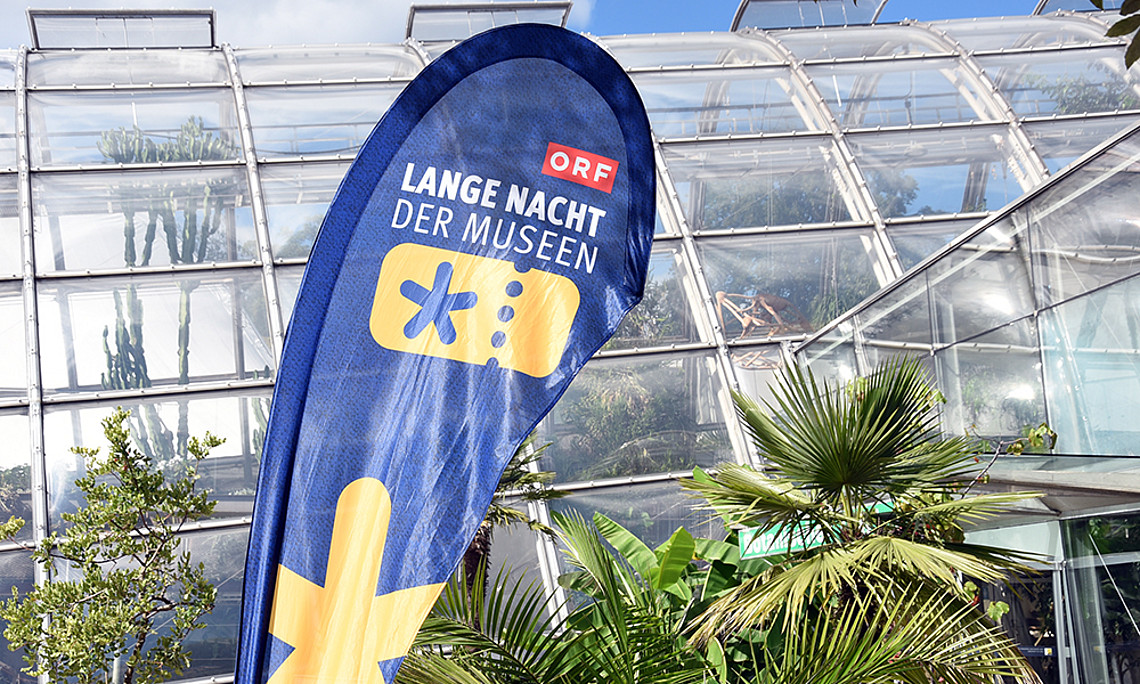 Beachflag der Langen Nacht der Museen vor dem Gewächshaus der Universität Graz; Foto: Uni Graz/Eklaude
