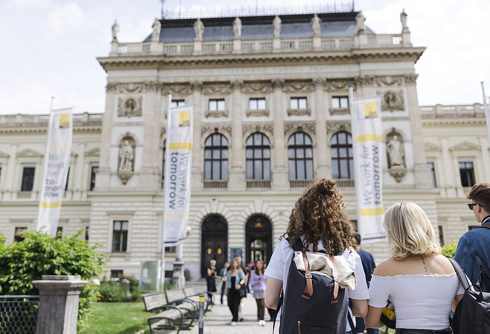 Studierende gehen aufs Hauptgebäude der Uni Graz zu