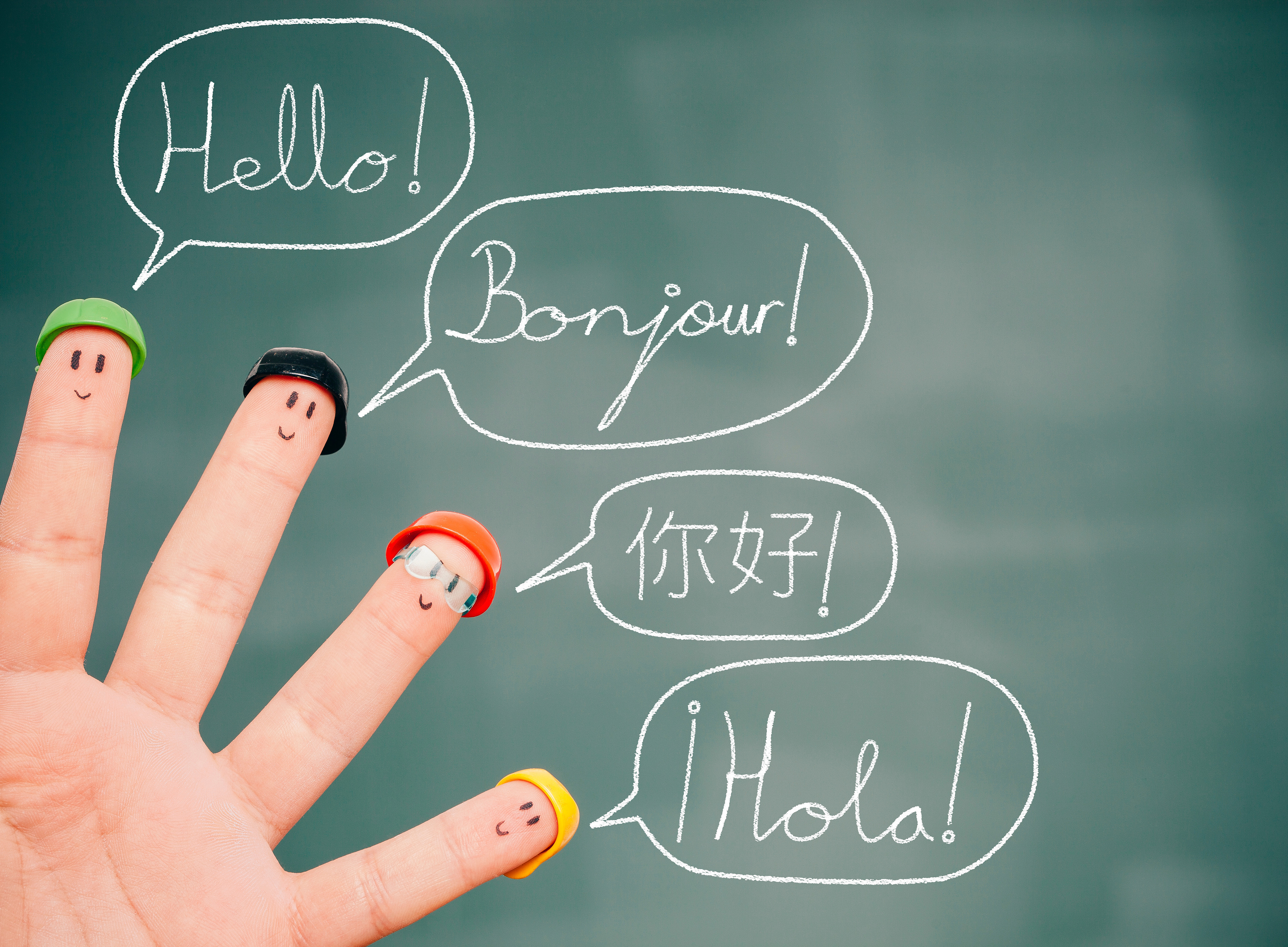 Finger mit aufgemalten Gesichtern und Sprechblasen 