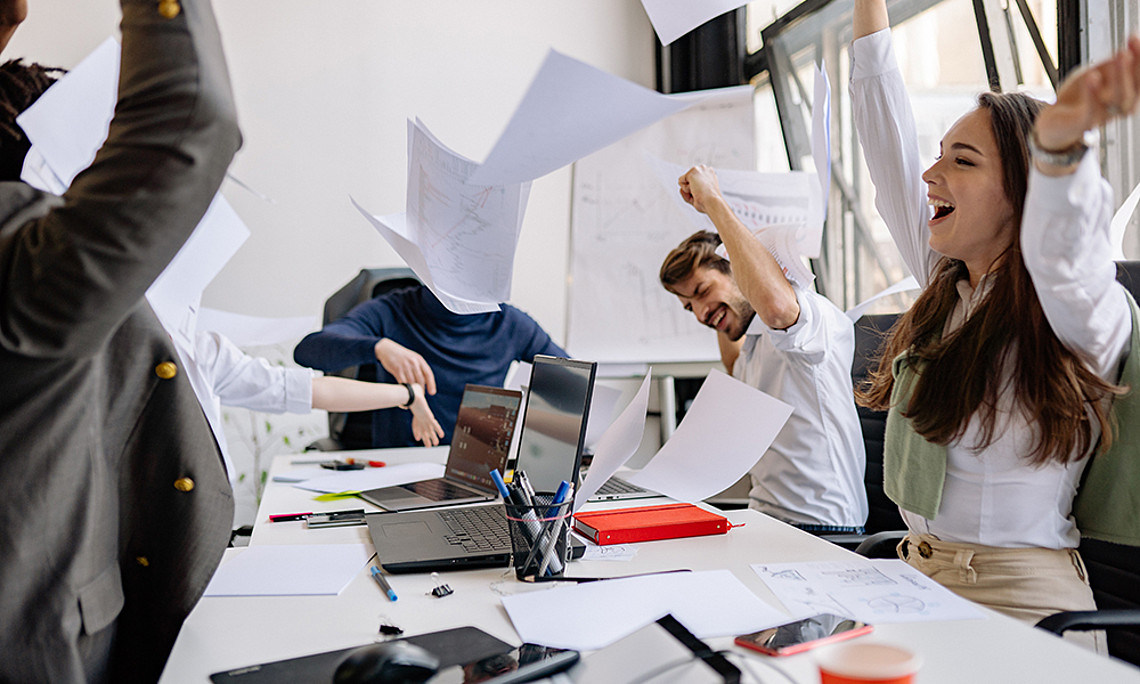 Team, Papierblätter fliegen in die Luft