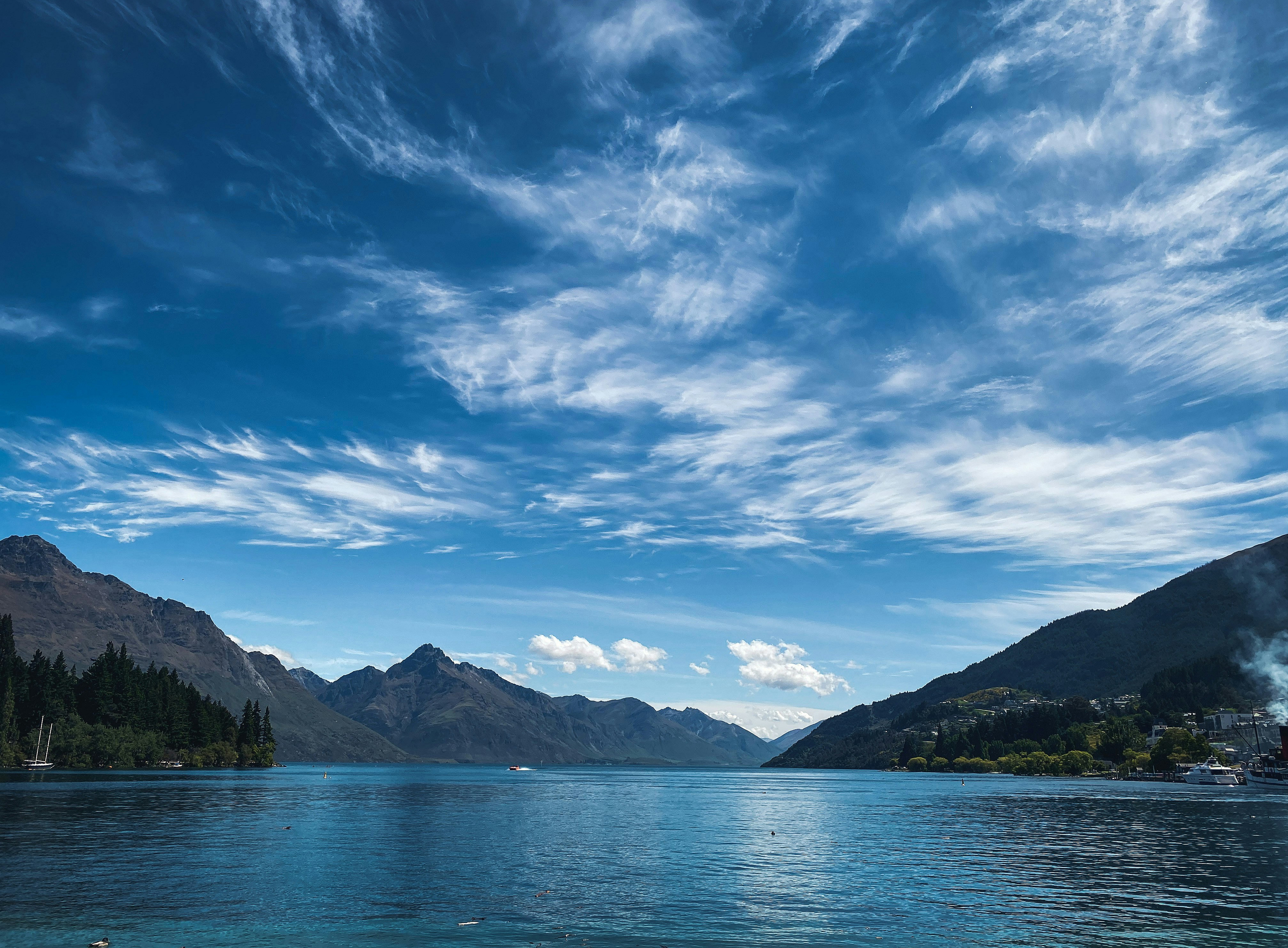 Blauer See mit Bergen und Wolken 