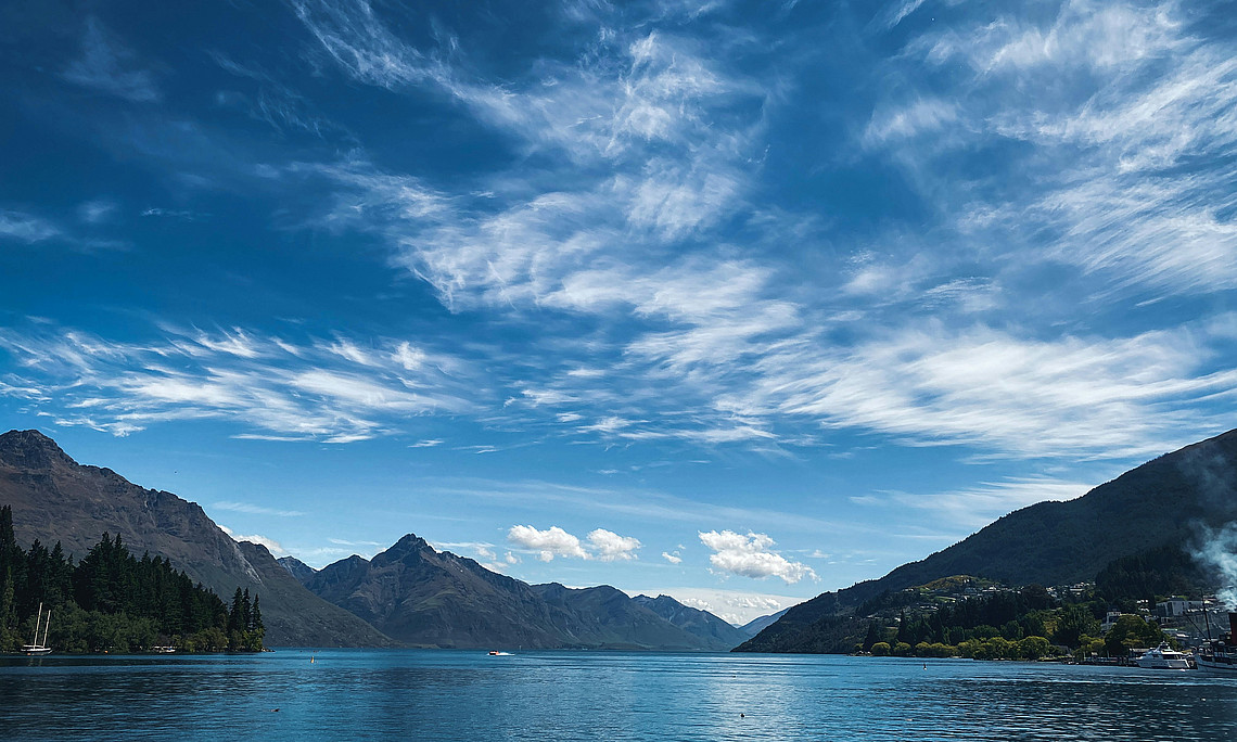 Blauer See mit Bergen und Wolken