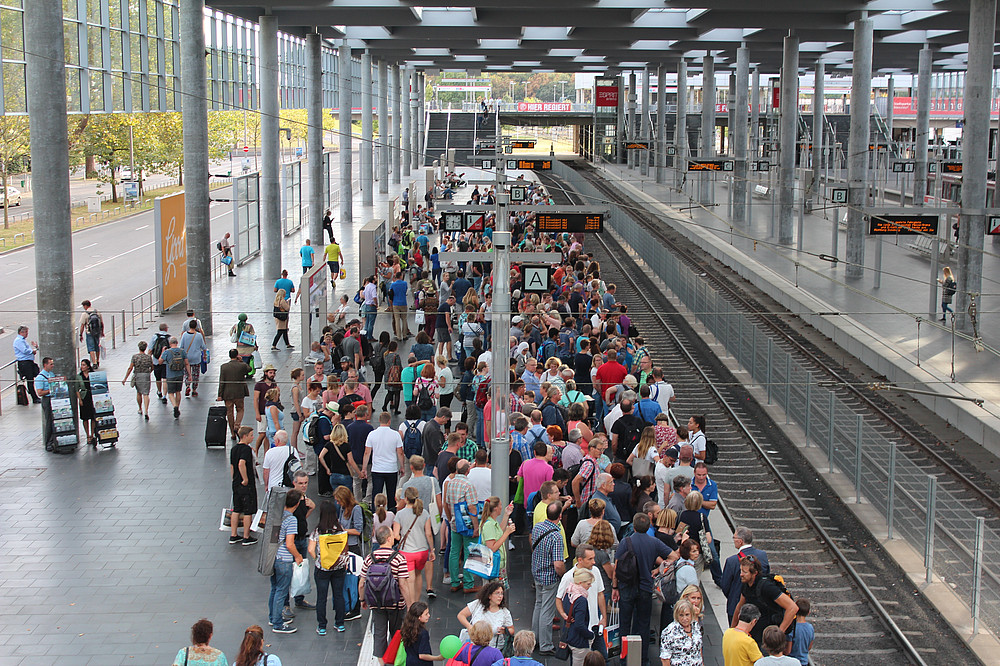 Menschen stehen am Bahnsteig und warten auf den einfahrenden Zug und symbolisieren die Forschungsgruppe EconClim ©pixabay