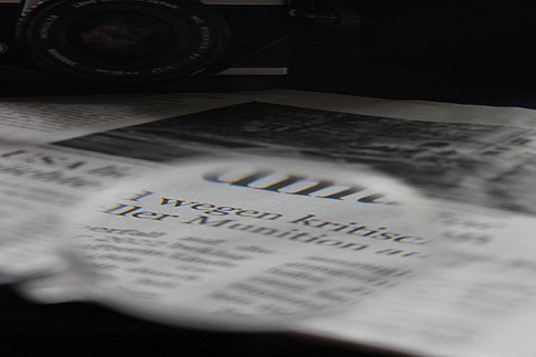 Zeitungsausschnit mit Lupe 